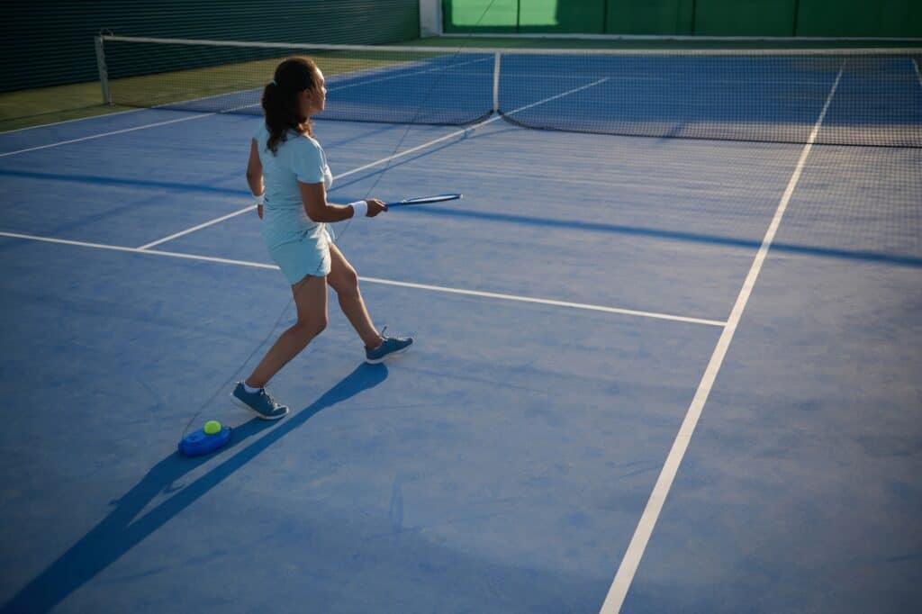 A female athlete is practising on a tennis court