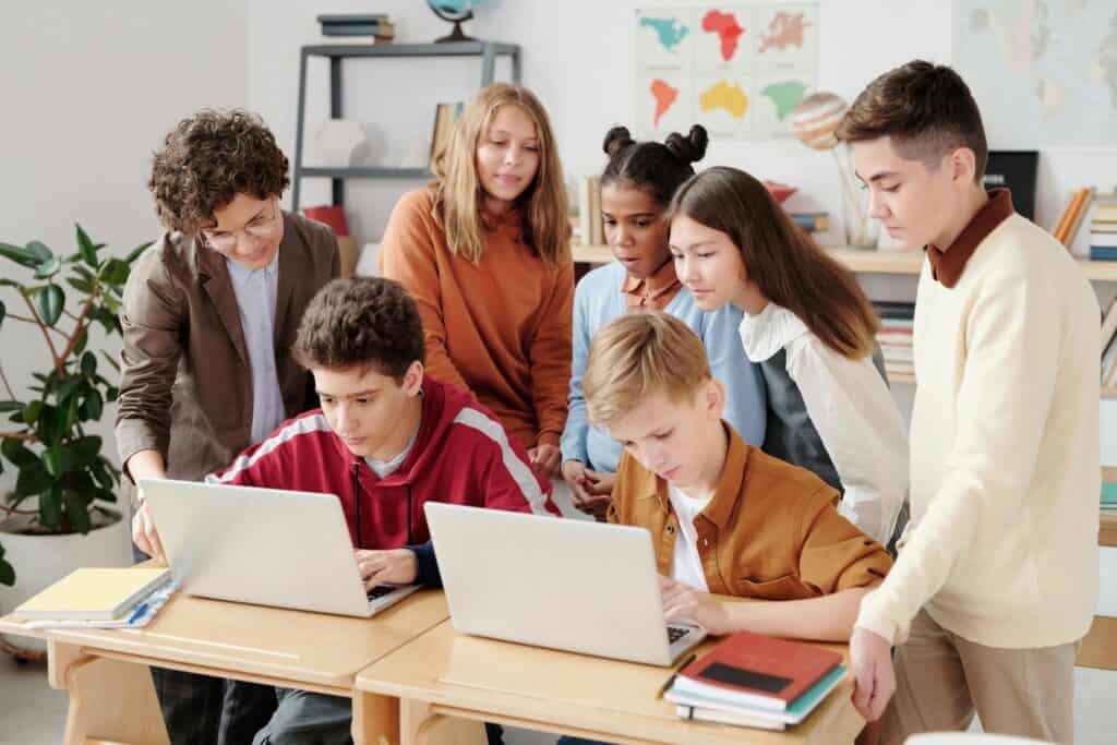 The students are working together as they are in front of the laptops in the concept of schools in Barnet.